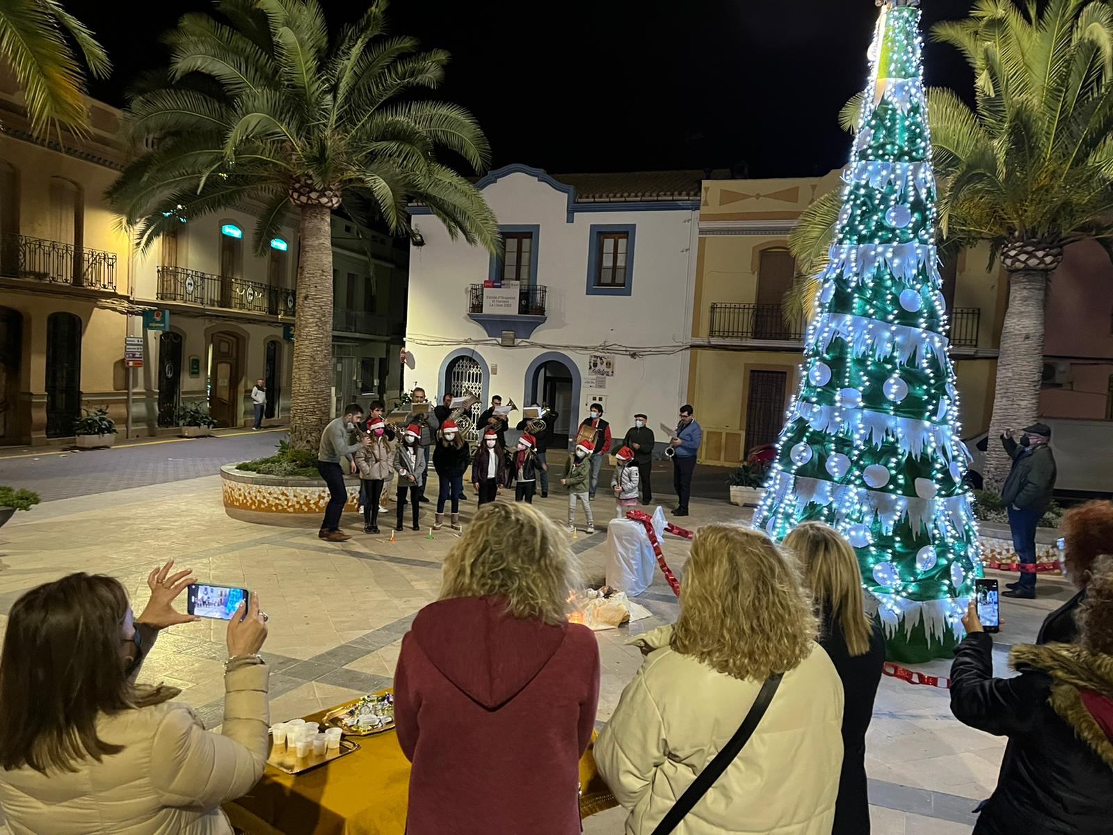Las amas de casa encienden el árbol de Navidad en la plaza del pueblo de La Llosa